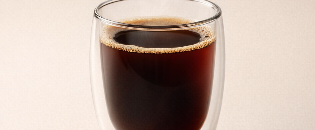 Steaming black coffee in a double-walled glass