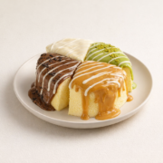 fluffy-menu-whole-cheesecake-mixed-sauce-7-1775610776.png Four slices of cake with different sauces.